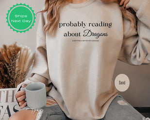 a woman wearing a sweatshirt that says, probably reading about dragons